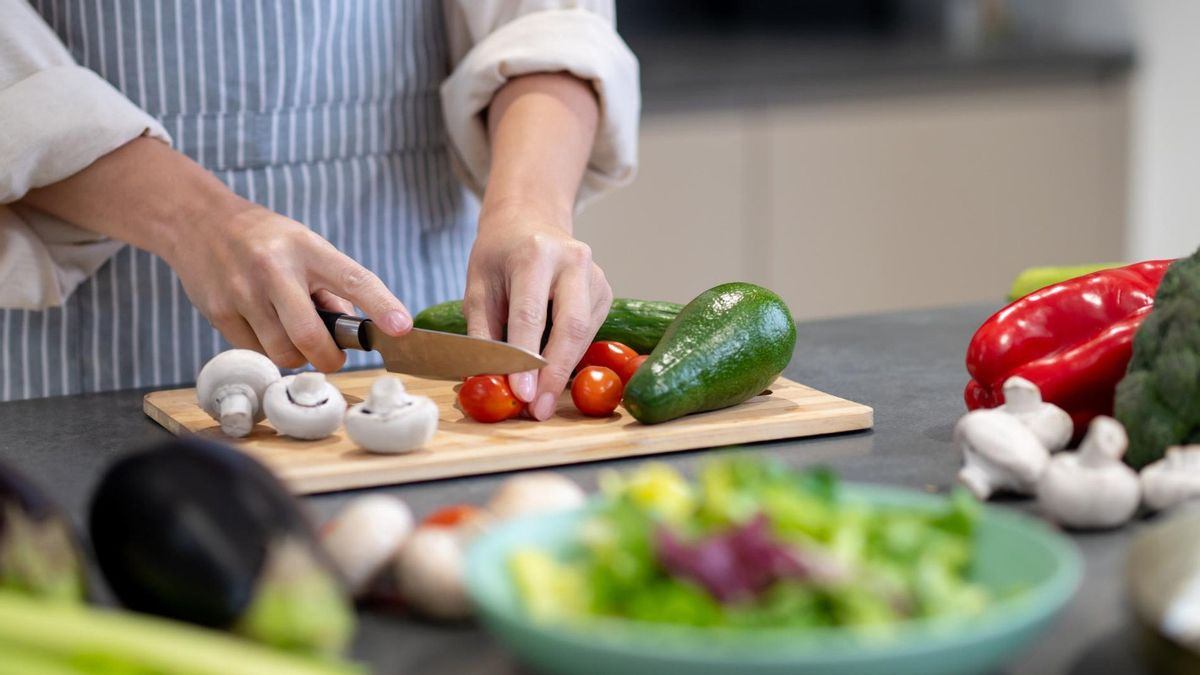 채소와 과일을 도마 위에 올려두고 토마토를 썰고 있는 모습으로, 당뇨 관리에 도움이 되는 식단과 자연식 재료 준비 장면을 표현한 이미지.